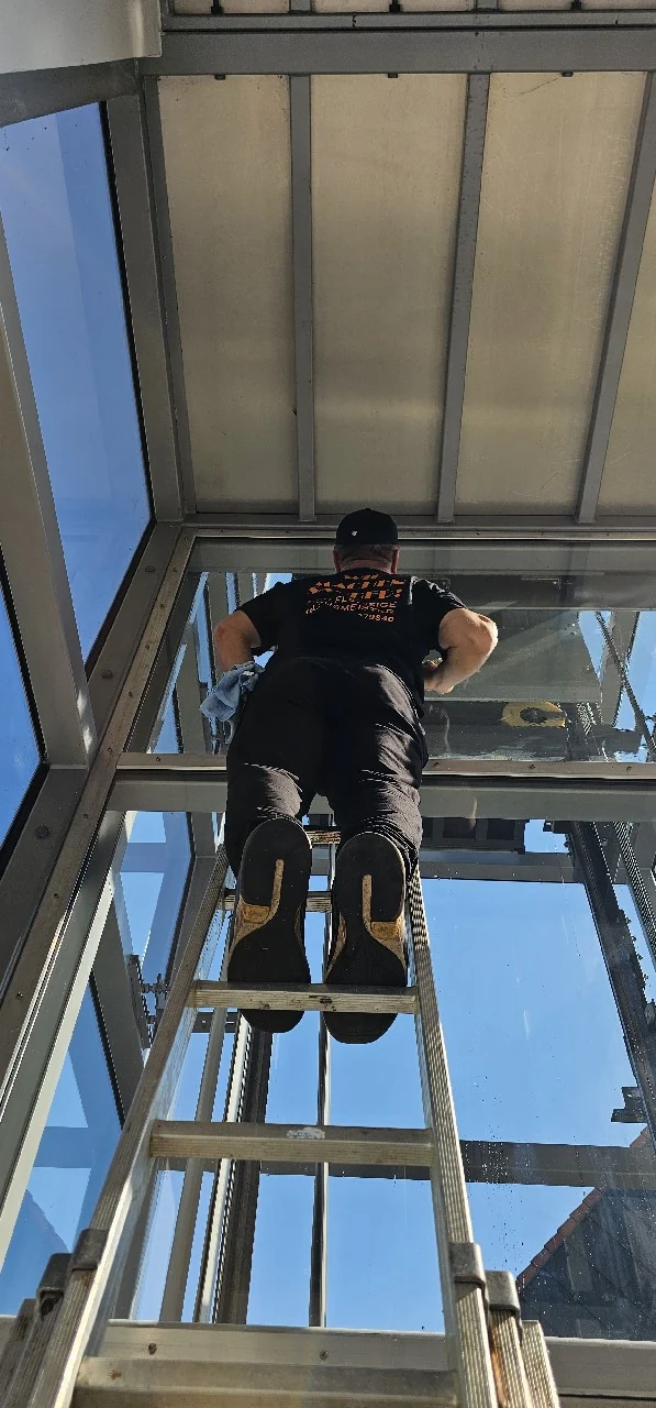 Mitarbeiter bei der Reinigung hoher Glasflächen