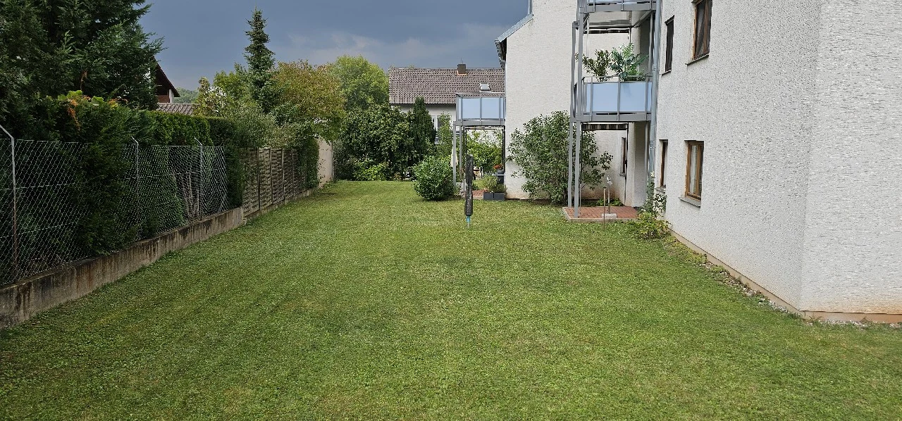 Gepflegte Rasenfläche neben einer Wohnanlage