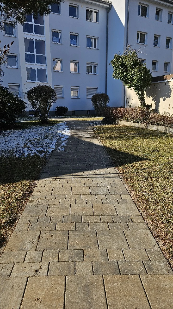 Geräumter Gehweg an einer Wohnanlage im Winter