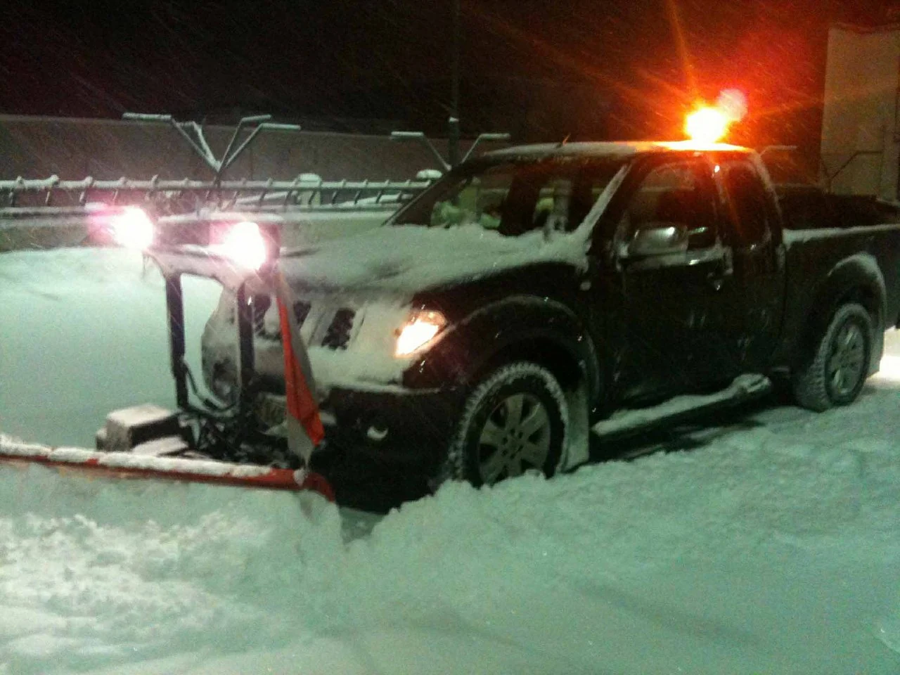Winterdienstfahrzeug bei starkem Schneefall in der Nacht
