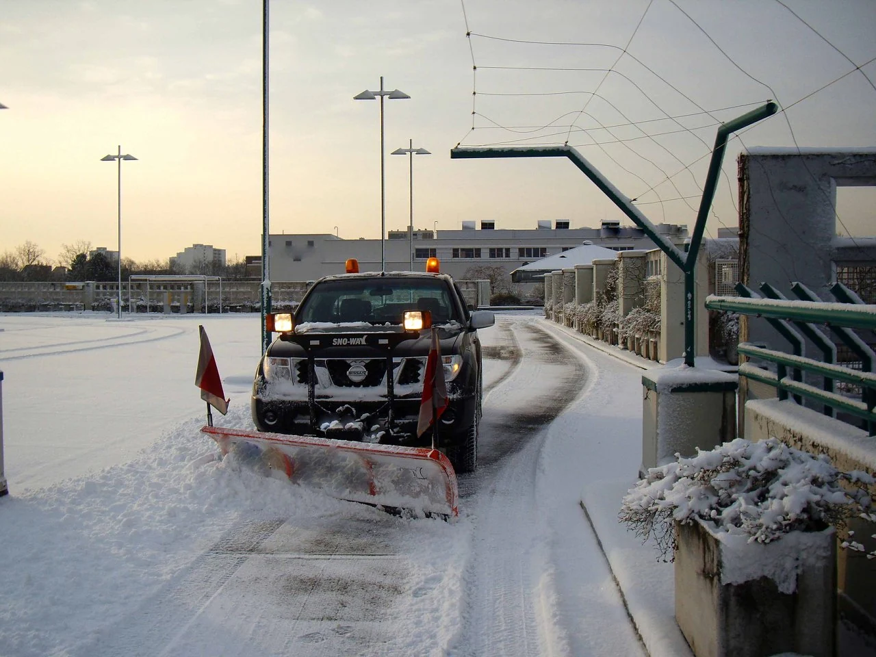 Winterdienstfahrzeug beim Räumen einer verschneiten Straße
